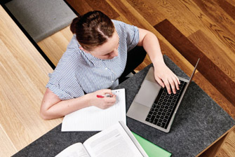Female caucasian writing notes from laptop