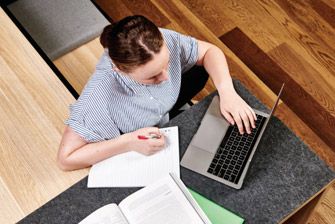 Female caucasian writing notes from laptop