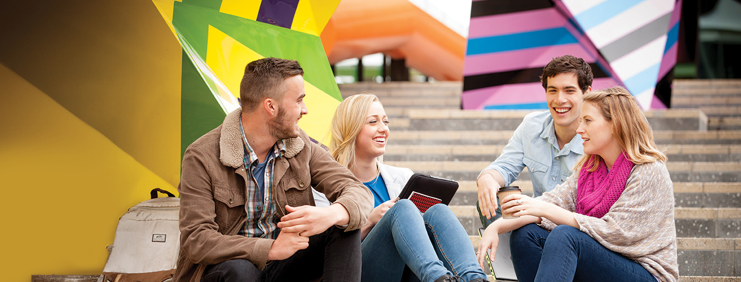 Student sitting outside on the stairs in college