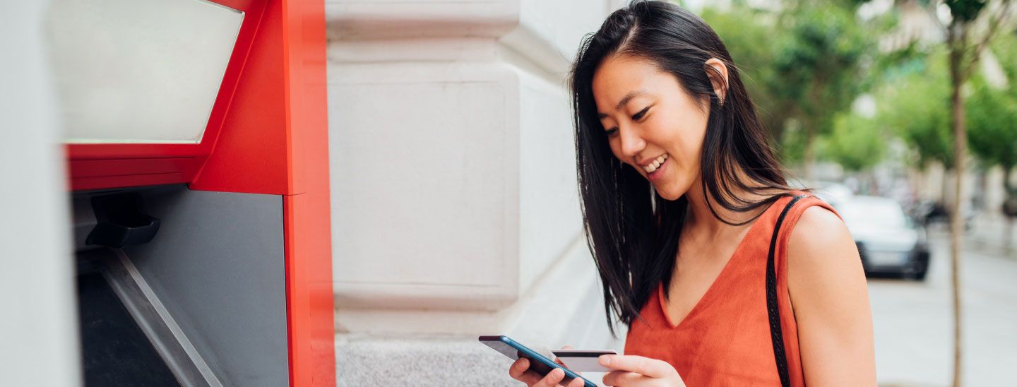 Female checking bank account at ATM