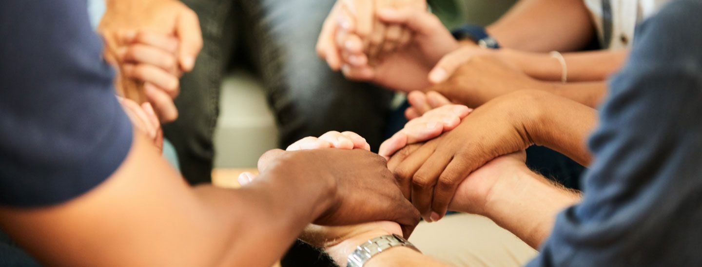 Group holding hands praying