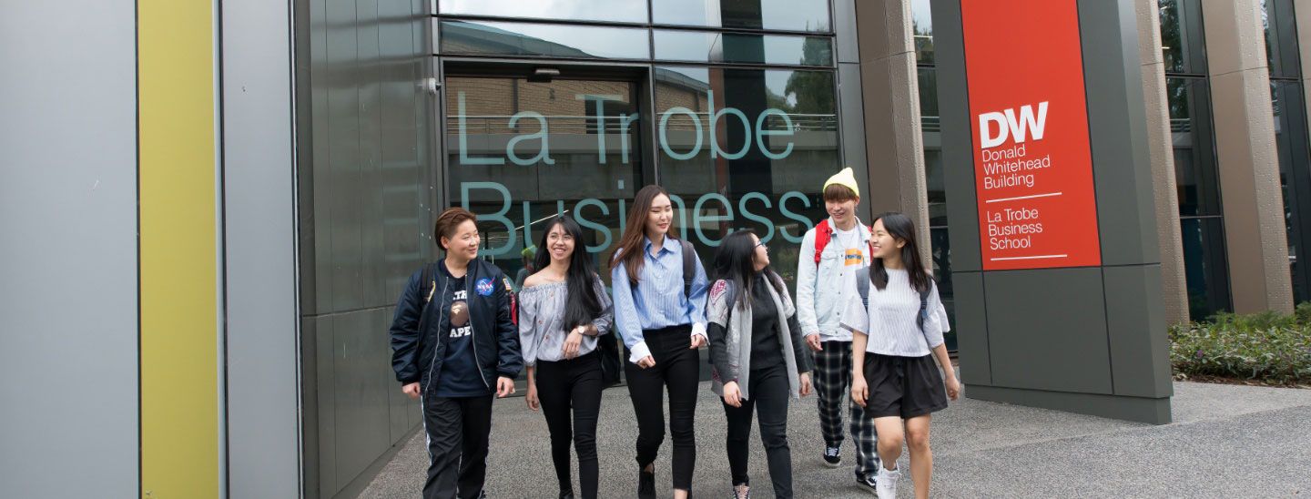 Group of students walking out of campus building