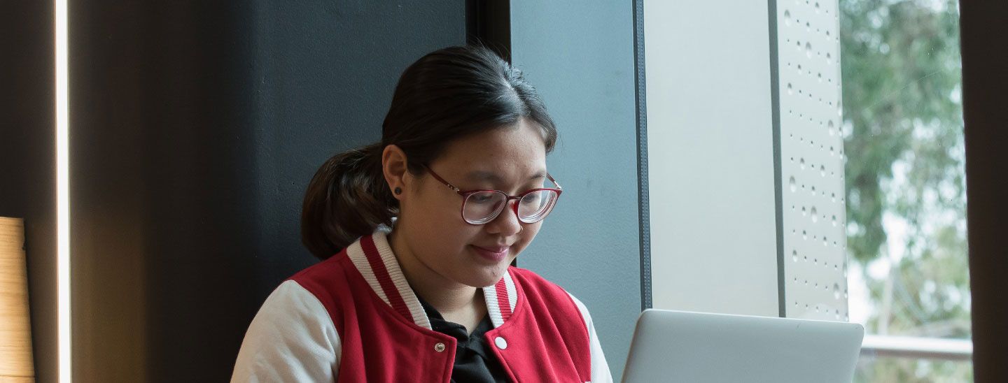International female student on laptop