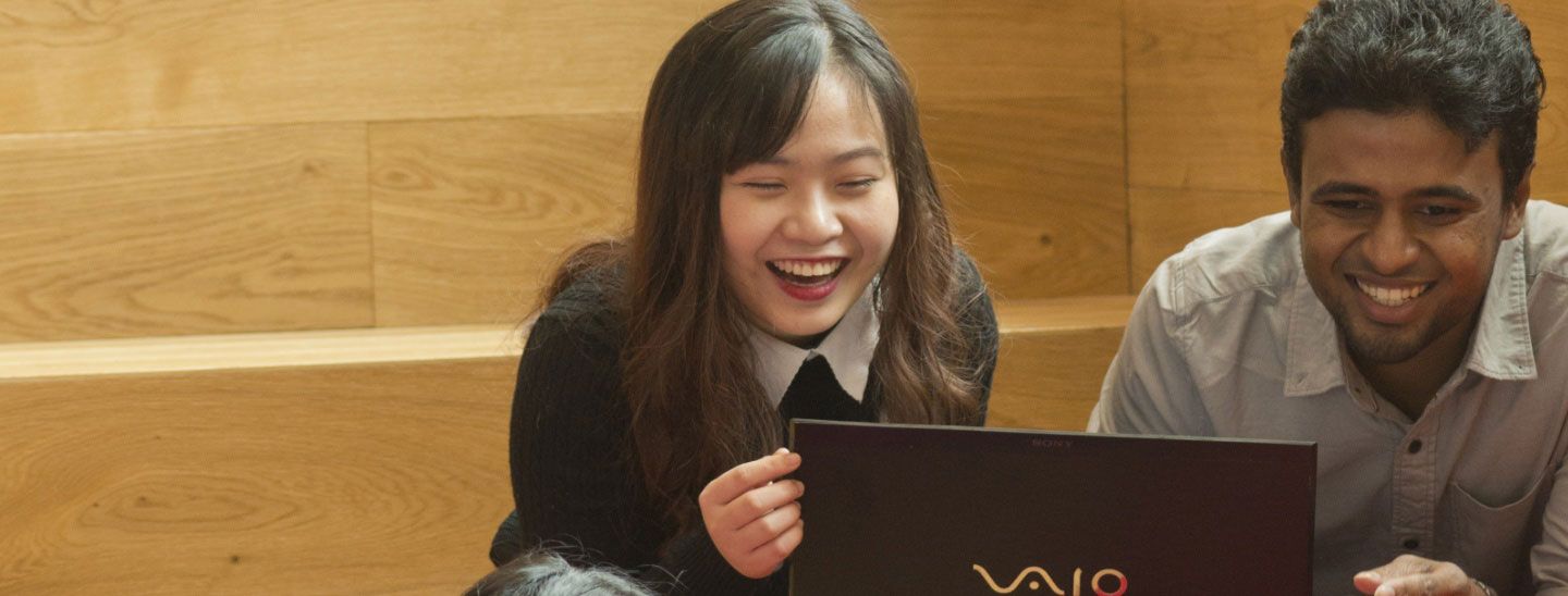 International student group looking at laptops