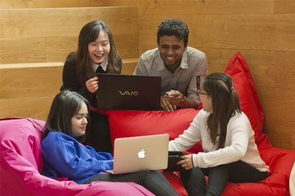 International student group looking at laptops