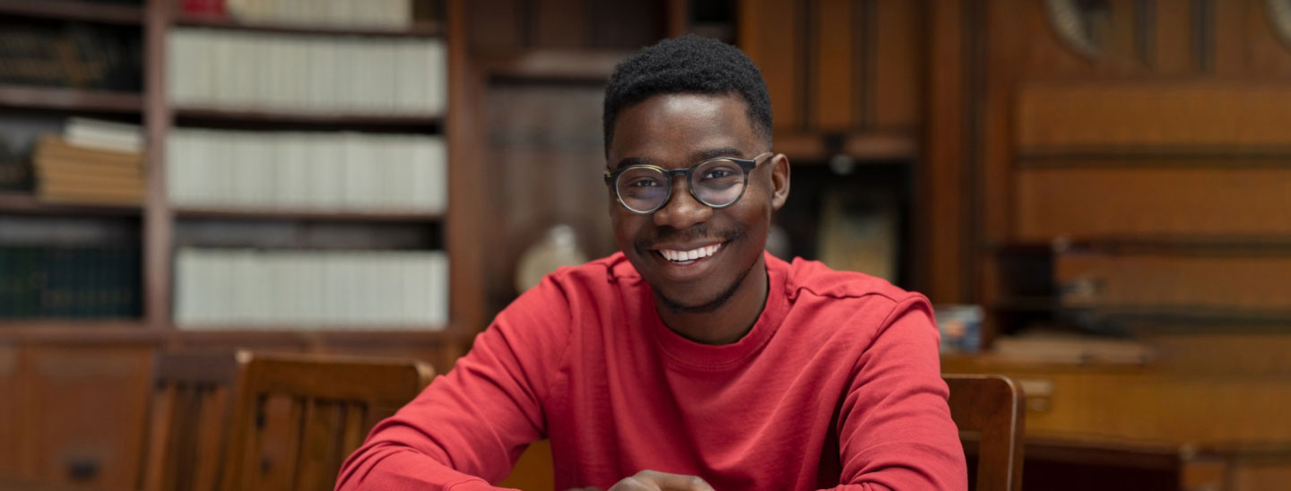 Male student smiling-studying library