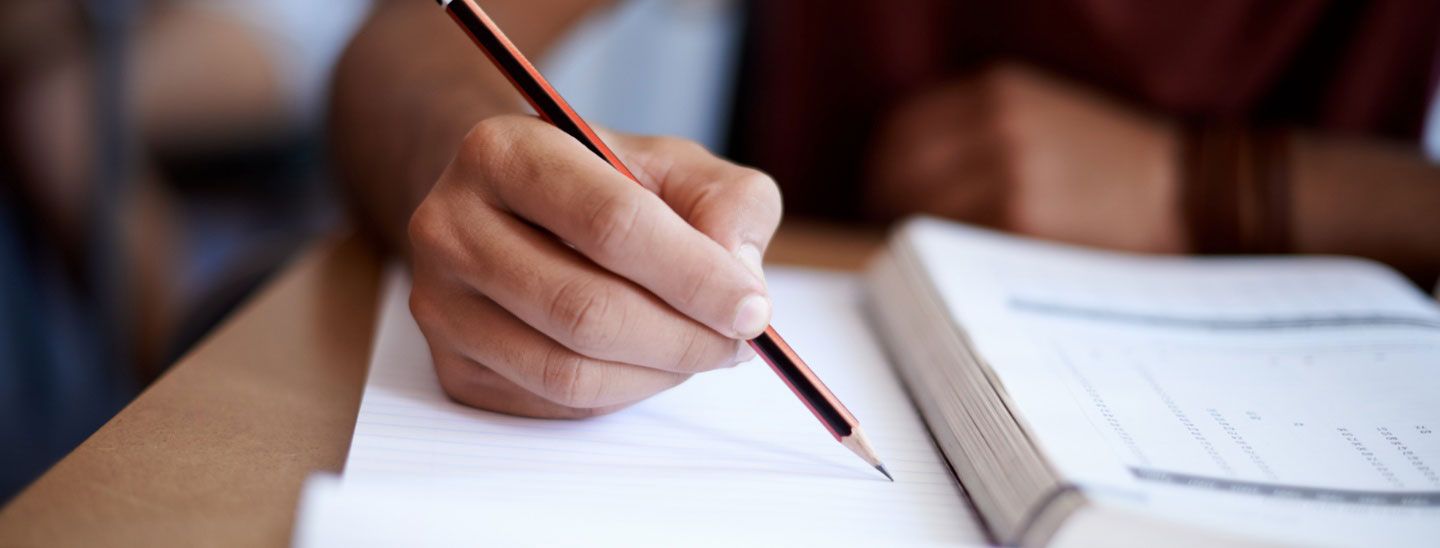 Male student writing in handbook