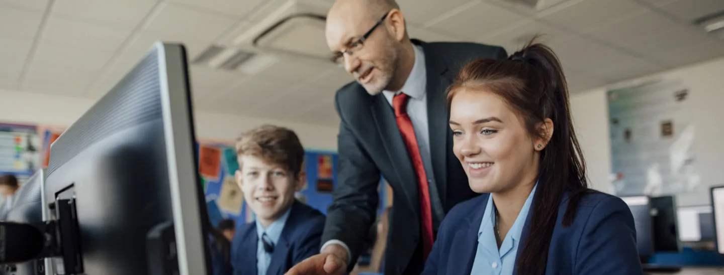 School students guided by teacher in computer room
