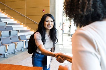 Student shaking teacher hand