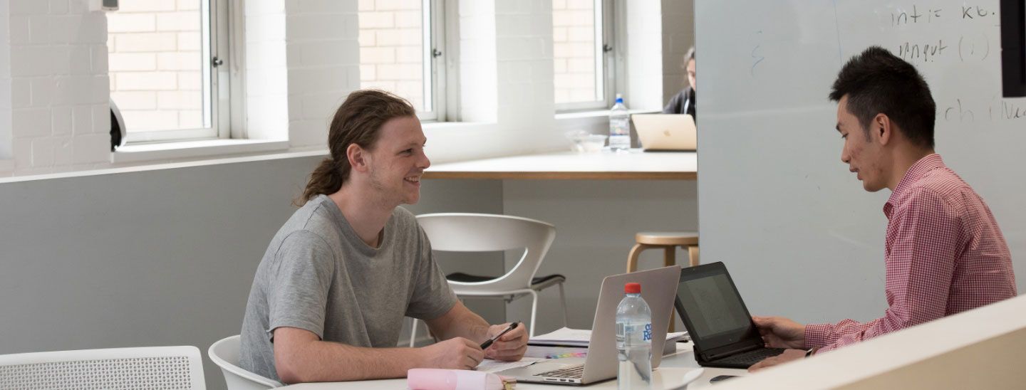 Teacher discussing with student in classroom